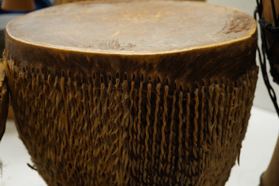 Five African drums; a Djembe, 50cm high, together with four others, including a pottery triple drum, etc. Condition - fair to good.